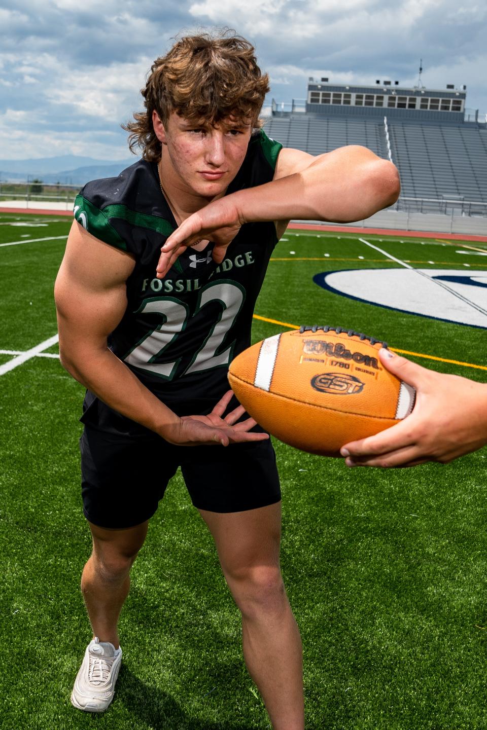 Fossil Ridge's Jake Toshcoff takes a handoff at the Coloradoan's high school football Media Day at PSD Stadium on Aug. 1.