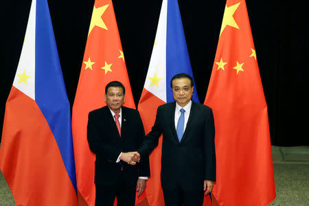 Philippines President Rodrigo Duterte (L) shakes hands with Chinese Premier Li Keqiang (R) ahead of their meeting at the Great Hall of the People in Beijing, China, October 20, 2016. REUTERS/Wu Hong/Pool