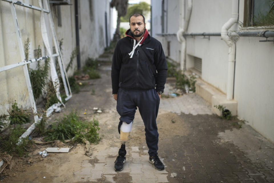 Walid Kasraoui, 32, a protester who lost a leg after getting shot during Tunisia's democratic uprising 10 years ago, poses for a portrait in Tunis, Tunisia, Tuesday, Jan. 12, 2021. Kasraoui lost a leg and has relied on crutches for a decade, but says he has no regrets. "If I went back in time to the events of the revolution, I would participate again," he says. (AP Photo/Mosa'ab Elshamy)