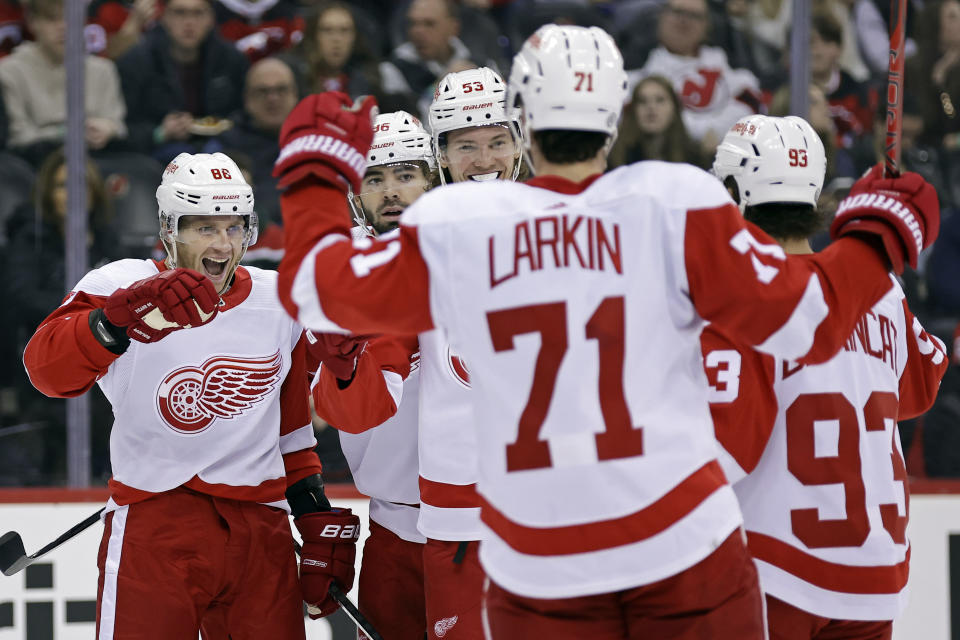 Detroit Red Wings right wing Patrick Kane, left, is congratulated by teammates after scoring a goal against the New Jersey Devils during the first period of an NHL hockey game Saturday, Dec. 23, 2023, in Newark, N.J. (AP Photo/Adam Hunger)