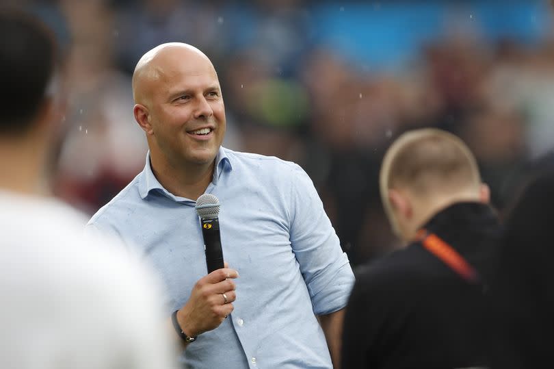 Arne Slot holds a microphone as he addresses Feyenoord fans at his final game in charge of the club