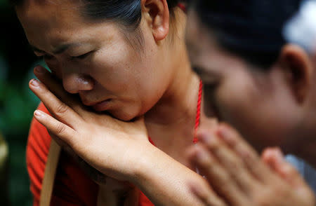 Family members pray near the Tham Luang cave complex during a search for members of an under-16 soccer team and their coach, in the northern province of Chiang Rai, Thailand, June 27, 2018. REUTERS/Soe Zeya Tun