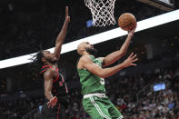 Boston Celtics guard Derrick White (9) drives to the basket as Toronto Raptors guard Immanuel Quickley (5) defends during second-half NBA basketball game action in Toronto, Monday Jan. 15, 2024. (Nathan Denette/The Canadian Press via AP)