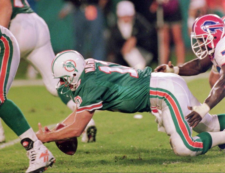 Miami Dolphins' quarterback Dan Marino gets stripped of the ball by Buffalo Bills' Bruce Smith during second quarter of their game in Miami Sunday Dec. 4, 1994.