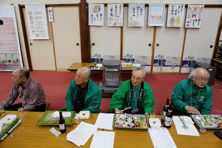 Members of the Bald Men Club, eat dinner as they watch a unique game of tug-of-war by attaching suction pads onto their heads, at a hot spring facility in Tsuruta town, Aomori prefecture, Japan, February 22, 2017. REUTERS/Megumi Lim