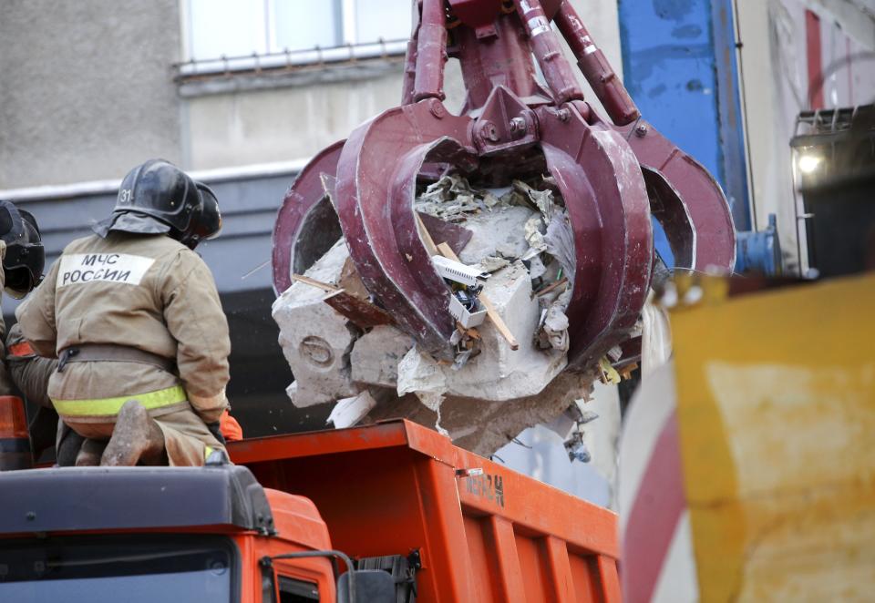 Emergency Situations employees look at debris of damaged parts of a collapsed apartment building in Magnitogorsk, a city of 400,000 people, about 1,400 kilometers (870 miles) southeast of Moscow, Russia, Wednesday, Jan. 2, 2019. Search crews have pulled more bodies from a huge pile of rubble at a collapsed Russian apartment building. The building's pre-dawn collapse on Monday came after an explosion that was believed to have been caused by a gas leak. (AP Photo/Maxim Shmakov)