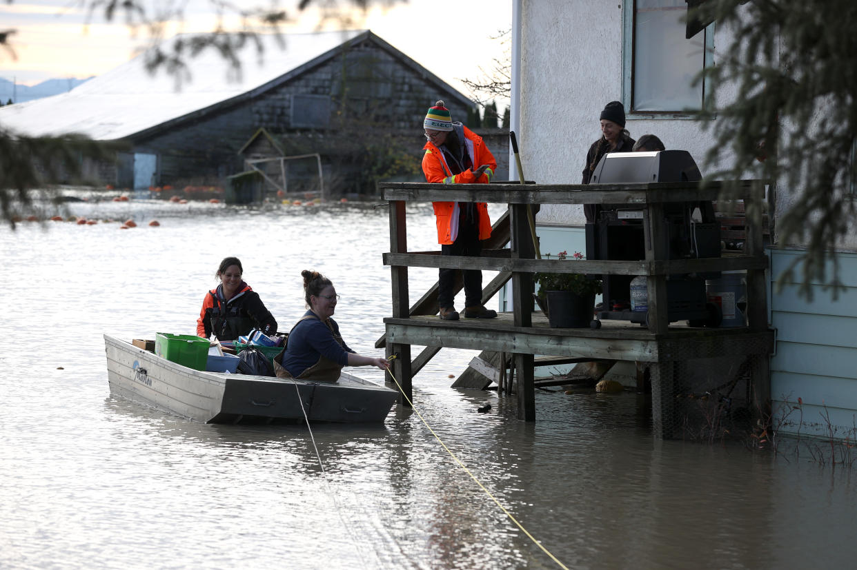 Chantel Penner is pulled in a boat from her parents' flooded home on Nov. 21 in Abbotsford, British Columbia. 