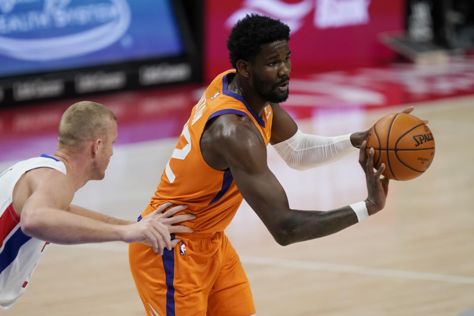 Phoenix Suns center Deandre Ayton, right, passes as Detroit Pistons center Mason Plumlee defends during the first half of an NBA basketball game, Friday, Jan. 8, 2021, in Detroit. (AP Photo/Carlos Osorio)