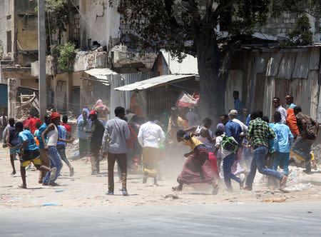 Civilians run from the scene of an explosion after al-Shabaab militia stormed a government building in Mogadishu, Somalia March 23, 2019. REUTERS/Feisal Omar