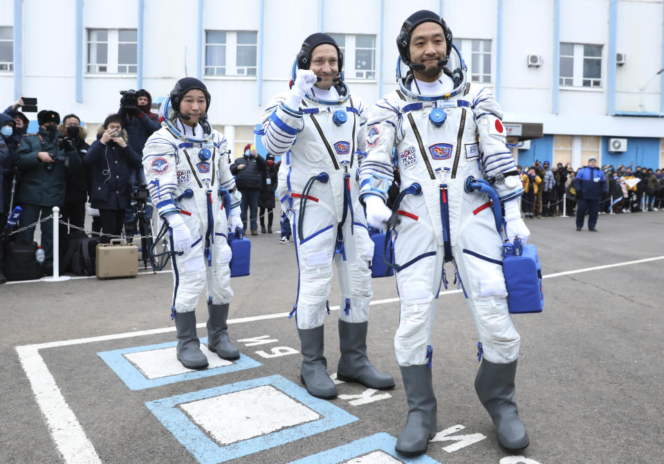 In this photo released by the Roscosmos Space Agency, Roscosmos cosmonaut Alexander Misurkin, center, and spaceflight participants Yusaku Maezawa, left, and Yozo Hirano, right, of Japan, members of the main crew of the new Soyuz mission to the International Space Station (ISS) walk prior to the launch at the Russian leased Baikonur cosmodrome, Kazakhstan, Wednesday, Dec. 8, 2021. (Pavel Kassin/Roscosmos Space Agency via AP)