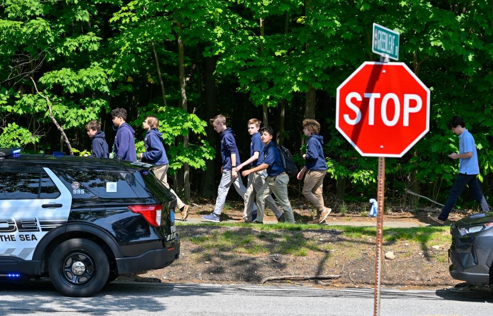 Students walk up a hill toward St. John's Prep in Danvers, Massachusetts, after a hoax call of an active shooter on Monday, May 22, 2023.