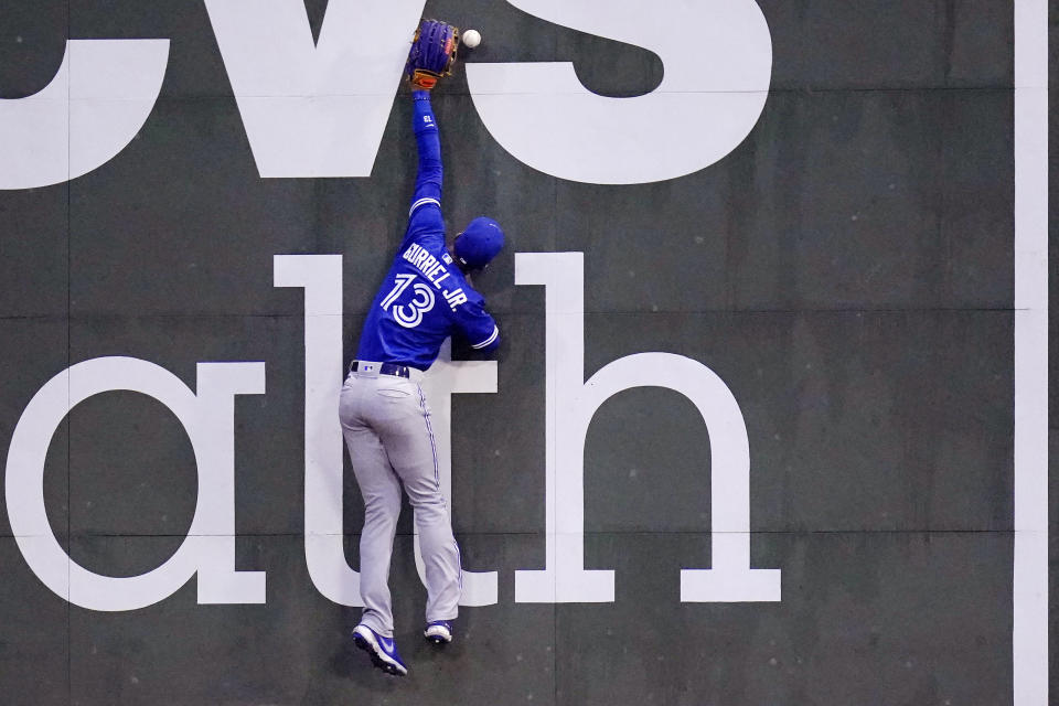 Toronto Blue Jays left fielder Lourdes Gurriel Jr. leaps against the wall but cannot make the play on an RBI-double by Boston Red Sox's Alex Verdugo during the third inning of a baseball game at Fenway Park, Monday, June 14, 2021, in Boston. (AP Photo/Charles Krupa)