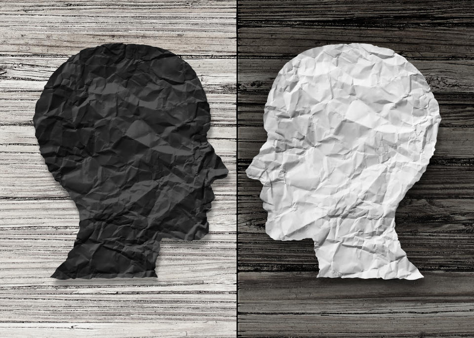 Bipolar mental health and brain disorder concept as a human head in paper divided in two colors as a neurological mood and emotion symbol or medical psychological metaphor for social behavior challenges in a 3D illustration style.