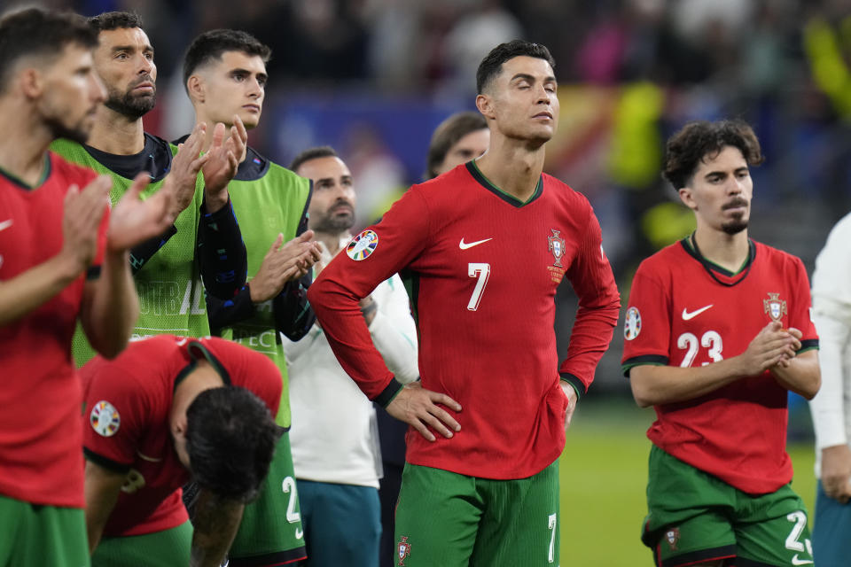 Portugal's Cristiano Ronaldo, center, reacts at the end of a quarter final match against France at the Euro 2024 soccer tournament in Hamburg, Germany, Friday, July 5, 2024. (AP Photo/Hassan Ammar)