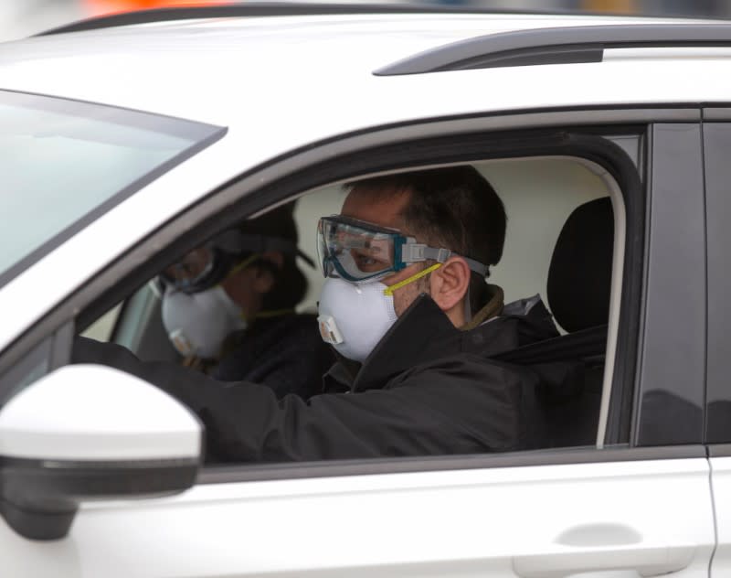 Two men wearing masks drive up for assessment as the city's public health unit holds walk-in testing for coronavirus disease (COVID-19) in Montreal