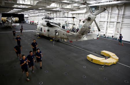 A female trainee (R front) of Japanese helicopter carrier Kaga jogs in the hangar deck of Japanese helicopter carrier Kaga in Indian Ocean, Indonesia, September 23, 2018. REUTERS/Kim Kyung-Hoon