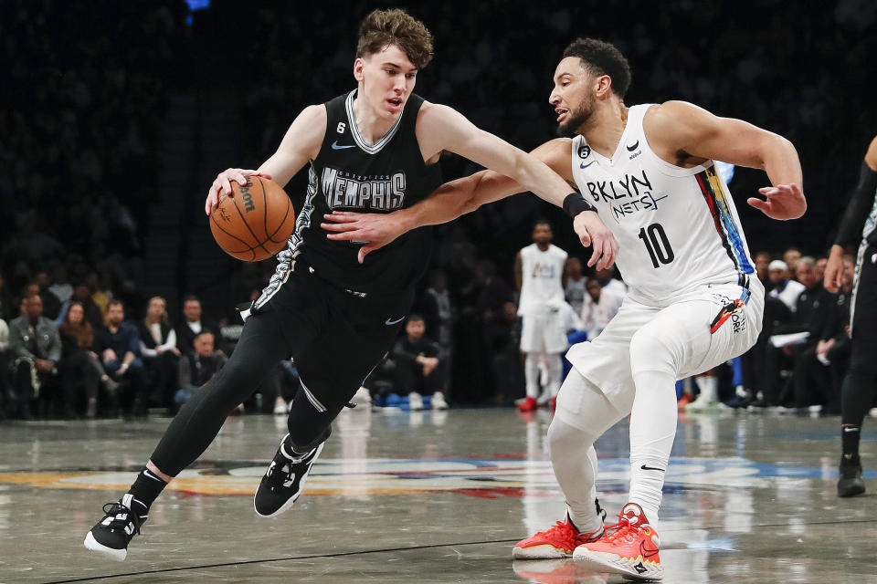 Memphis Grizzlies forward Jake LaRavia, left, dribbles against Brooklyn Nets forward Ben Simmons (10) during the second half of an NBA basketball game Sunday, Nov. 20, 2022, in New York. (AP Photo/Eduardo Munoz Alvarez)