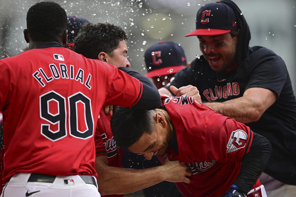 Cleveland Guardians' Andres Gimenez, bottom, celebrates with Estevan Florial (90) and Austin Hedges, right, after hitting a walkoff sacrifice fly in the 10th inning of a baseball game against the New York Yankees, Sunday, April 14, 2024, in Cleveland. (AP Photo/David Dermer)