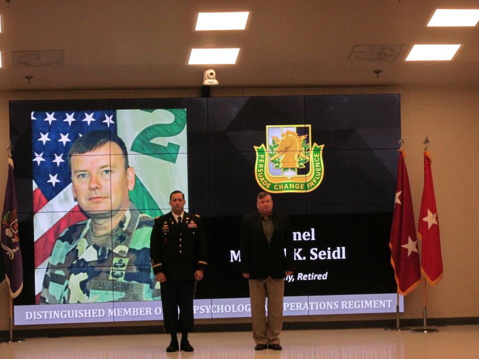 Retired Col. Michael Seidl is welcomed by Lt. Col. Jeffrey Souther as a distinguished member of the psychological operations regiment during a Nov. 4, 2021, ceremony at Fort Bragg.