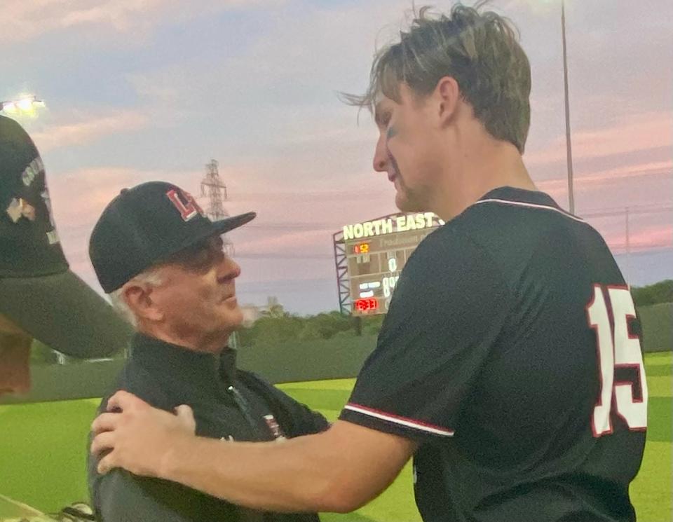 Lake Travis baseball coach Mike Rogers embraces first baseman Cole Johnson after the Cavaliers were beaten by San Antonio Reagan 6-2 in the Region IV championship game Saturday.