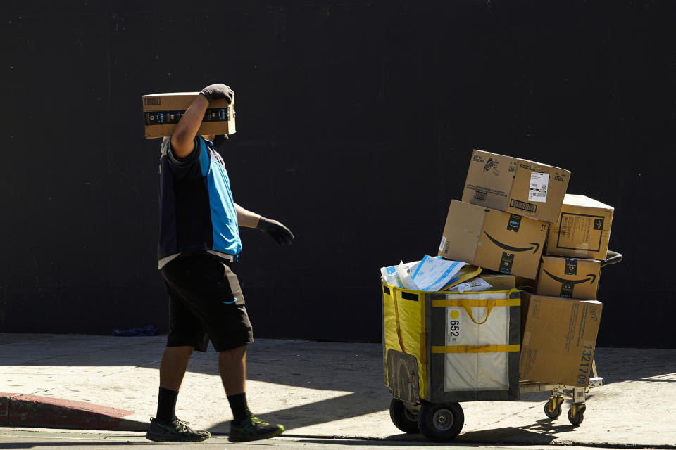 FILE - An Amazon worker delivers boxes in Los Angeles on Oct. 1, 2020. California is suing Amazon, accusing the company of violating the state’s antitrust and unfair competition laws by stifling competition and engaging in practices that push sellers to maintain higher prices on products on other sites. In an 84-page lawsuit filed Wednesday, Sept. 14, 2022 in San Francisco Superior Court, the California Attorney General's office said Amazon had effectively barred sellers from offering lower prices for products elsewhere through contract provisions that harm the ability of other retailers to compete. (AP Photo/Damian Dovarganes, File)