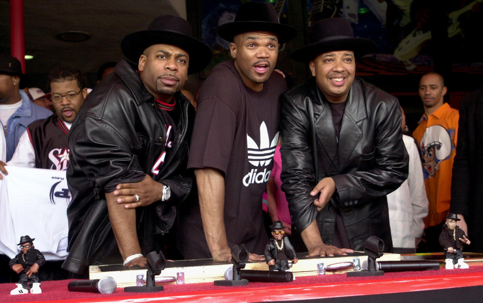 FILE - This Feb. 25, 2002 file photo shows members of the hip hop group RUN-DMC, from left, Jason "Jam Master Jay" Mizell, Darryl "DMC" McDaniels and Joseph "DJ Run" Simmons creating handprints in cement as they are inducted into Hollywood's RockWalk in Los Angeles.  It was announced Tuesday, July 10, 2012, that McDaniels and Simmons, the surviving members of Run-DMC, will reunite at the Fun Fun Fun Fest in Austin, Texas on Nov. 2-4. Simmons retired from the group after Mizell was shot to death in 2002. Festival organizers say they plan to donate some of the proceeds to the JMJ Foundation for Music, which works to give youth access to the arts. (AP Photo/Krista Niles, file)