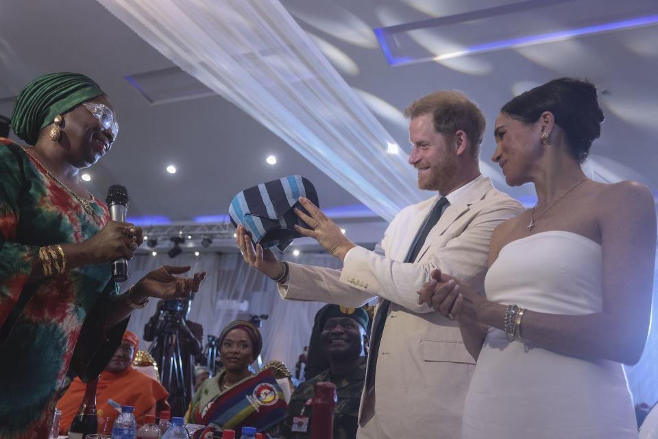 britain's prince harry 2nd l, duke of sussex, and britain's meghan r, duchess of sussex, receive a traditional outfit made in nigeria as they attend a sit out at the nigerian defence headquarters in abuja on may 11, 2024 as they visit nigeria as part of celebrations of invictus games anniversary photo by kola sulaimon afp