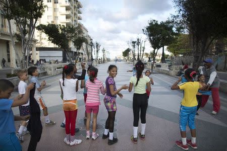 Children exercise during a fencing lesson outside their school in Havana November 28, 2014. REUTERS/Alexandre Meneghini