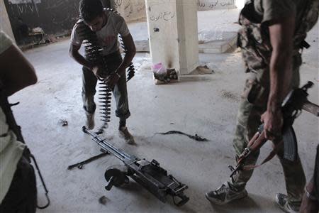 A Free Syrian Army fighter prepares his weapon in the al-Khalidiya neighbourhood of Aleppo, September 21, 2013. REUTERS/Aref Hretani