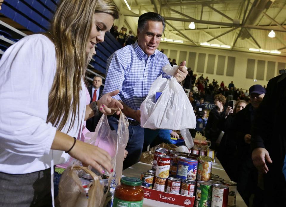 Republican presidential candidate, former Massachusetts Gov. Mitt Romney holds bags of food as he participates in a campaign event collecting supplies from residents local relief organizations for victims of superstorm Sandy, Tuesday, Oct. 30, 2012, at the James S. Trent Arena in Kettering, Ohio. (AP Photo/Charles Dharapak)