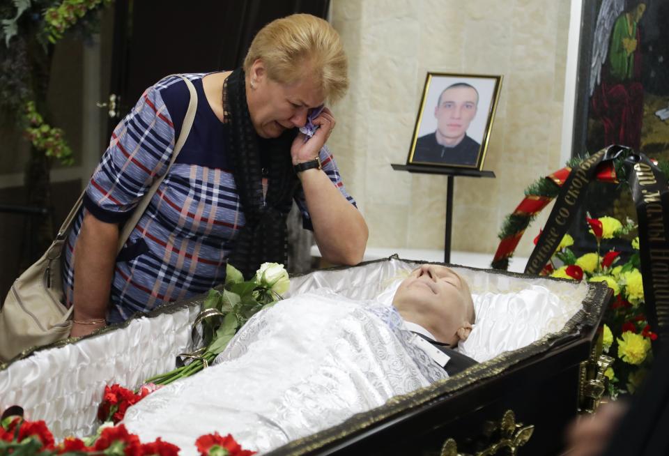 Mother of Alexander Taraikovsky, who died amid clashes protesting the election results, cries at the coffin during his funeral in Minsk, Belarus, Saturday, Aug. 15, 2020. Taraikovsky died Monday as demonstrators roiled the streets of the capital Minsk, denouncing official figures showing that authoritarian President Alexander Lukashenko, in power since 1994, had won a sixth term in office. (AP Photo/Sergei Grits)