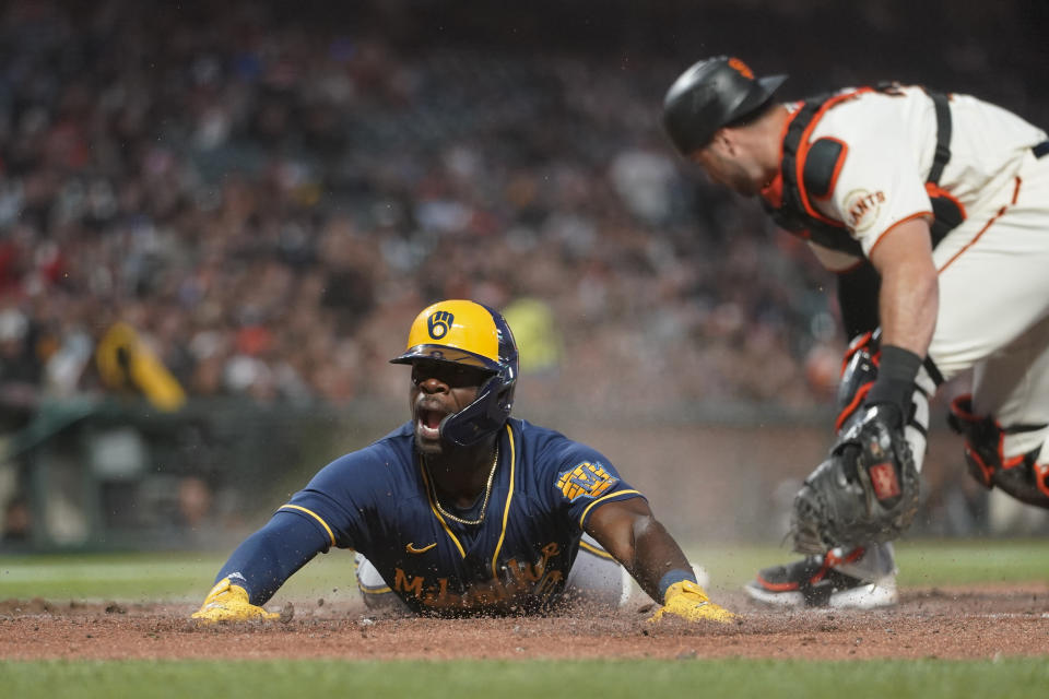 Milwaukee Brewers' Jonathan Davis scores next to San Francisco Giants catcher Joey Bart on a single by Willy Adames during the sixth inning of a baseball game in San Francisco, Thursday, July 14, 2022. (AP Photo/Godofredo A. Vásquez)