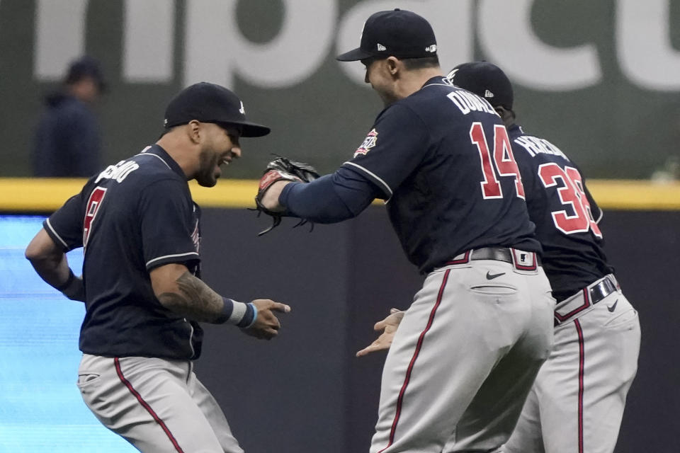 Atlanta Braves left fielder Eddie Rosario, from left, left fielder Adam Duvall and center fielder Guillermo Heredia celebrates their win against the Milwaukee Brewers in Game 2 of baseball's National League Divisional Series Saturday, Oct. 9, 2021, in Milwaukee. (AP Photo/Morry Gash)