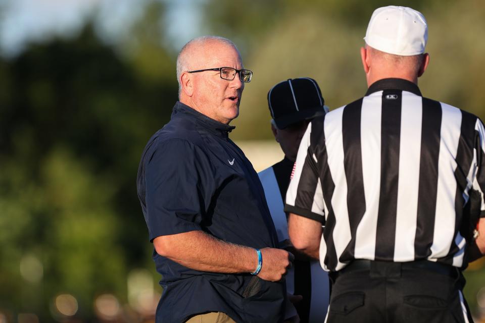 Pittsford's Head Coach Keith Molinich talks to the referee before a high school football game at McQuaid Jesuit High School.