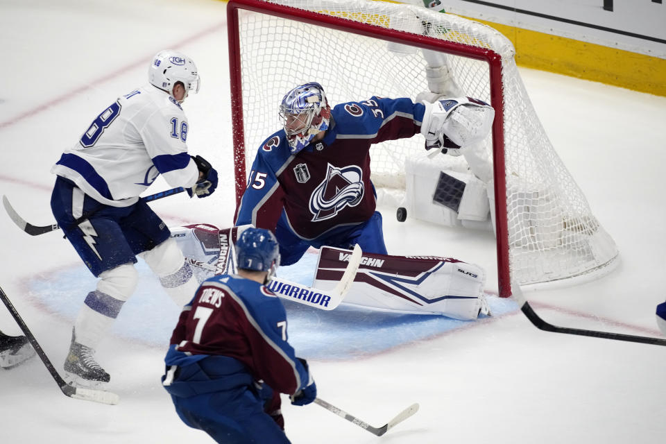 Tampa Bay Lightning left wing Ondrej Palat, left, scores past Colorado Avalanche goaltender Darcy Kuemper during the second period of Game 1 of the NHL hockey Stanley Cup Final on Wednesday, June 15, 2022, in Denver. (AP Photo/David Zalubowski)