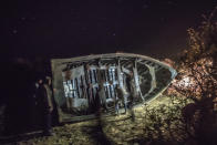 Smugglers turn over a recently built fishing boat intended to carry migrants to the Canary Islands, in a remote desert out of the town of Dakhla in Morocco-administered Western Sahara, Tuesday, Dec. 22, 2020. (AP Photo/Mosa'ab Elshamy)