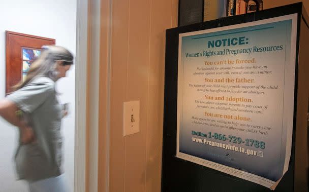 PHOTO: An abortion clinic staffer passes a women's rights poster at Hope Medical Group for Women in Shreveport, La., July 6, 2022.  (Ted Jackson/AP)