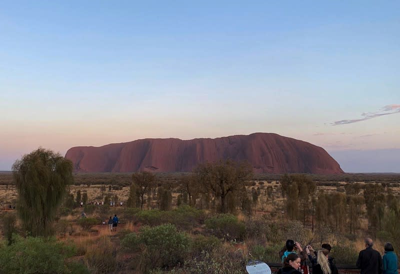 People view Uluru, the day before a permanent ban on climbing the monolith takes effect following a decades-long fight by indigenous people to close the trek, near Yulara