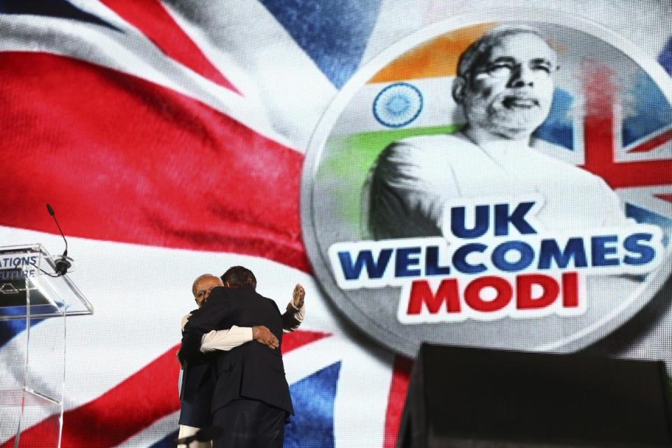 Narendra Modi embraces then British prime minister David Cameron on stage at Wembley Stadium in London on 13 November 2015 (AFP/Getty)