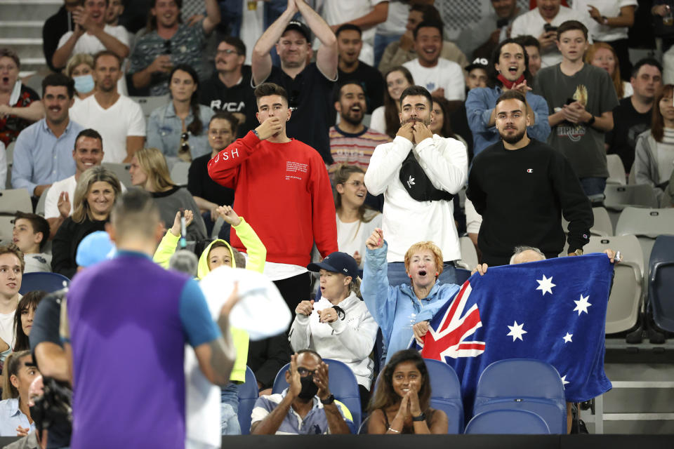 Fans cheer for Australia's Nick Kyrgios, back to camera, during his third round match against Austria's Dominic Thiem at the Australian Open tennis championship in Melbourne, Australia, Friday, Feb. 12, 2021.(AP Photo/Hamish Blair)