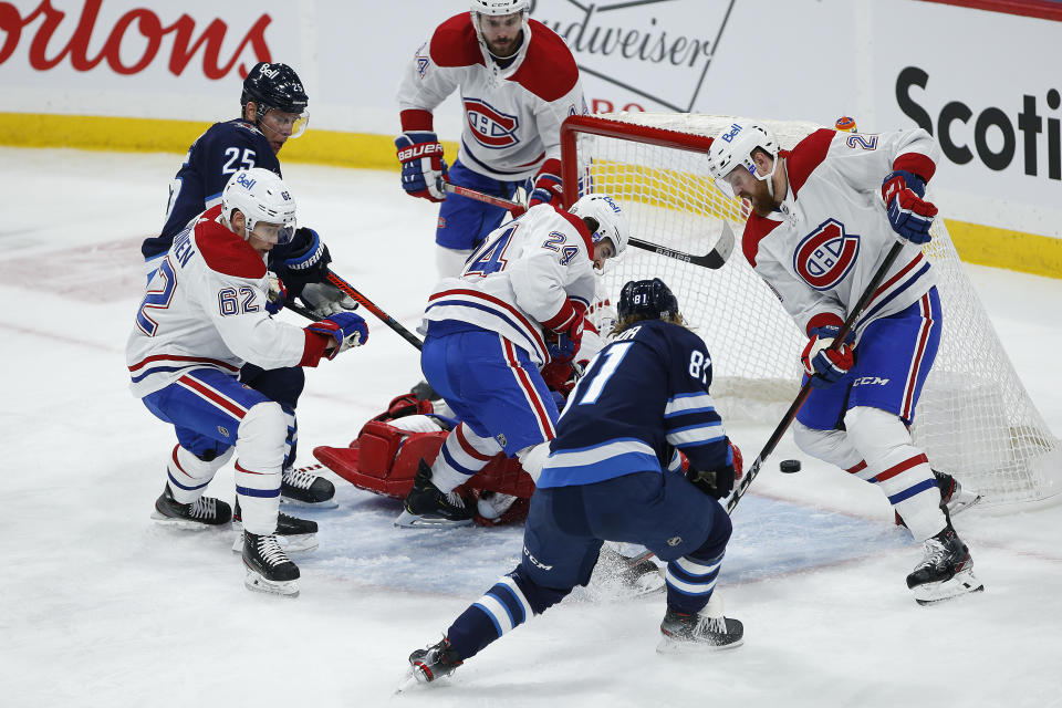 Winnipeg Jets' Kyle Connor (81) scores against Montreal Canadiens goaltender Carey Price, center bottom, during second-period NHL hockey game action in Winnipeg, Manitoba, Thursday, Feb. 25, 2021. (John Woods/The Canadian Press via AP)