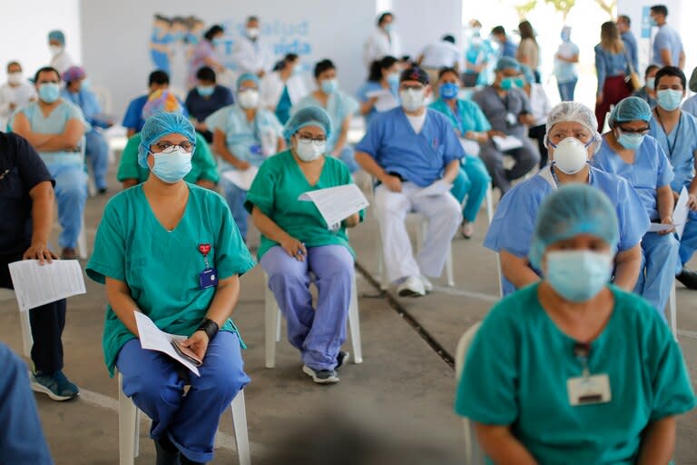 Trabajadores de salud peruanos de Lima hacen cola para recibir la primera dosis de la vacuna contra el coronavirus en Lima el 9 de febrero de 2021