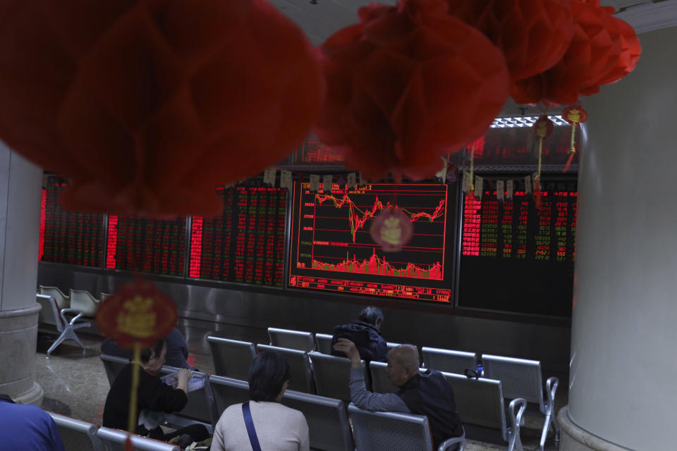 Investors monitor stock prices at a brokerage in Beijing, China, Thursday, Feb. 21, 2019. Asian stock markets were little-changed Thursday following a listless day on Wall Street ahead of U.S.-Chinese negotiations aimed at ending a tariff battle. (AP Photo/Ng Han Guan)