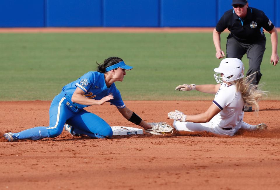 UCLA's Briana Perez (3) tags out Northwestern's Skyler Shellmyer (8) as she slides into second base during the first inning of an NCAA softball Women's College World Series game Friday, June 3, 2022, in Oklahoma City. (AP Photo/Alonzo Adams)