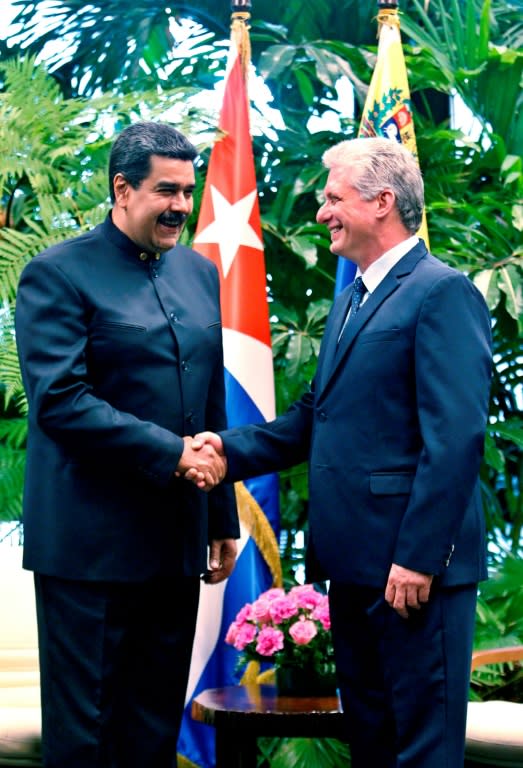 Cuba's newly elected President Miguel Diaz-Canel (R) shakes hands with Venezuela's Nicolas Maduro during a visit to Havana