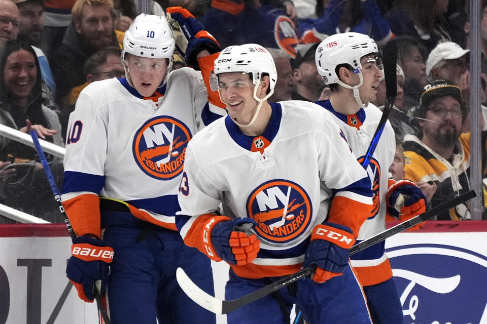 New York Islanders' Mathew Barzal, center, head back to the bench after scoring against the Pittsburgh Penguins during the second period of an NHL hockey game in Pittsburgh, Tuesday, Feb. 20, 2024. (AP Photo/Gene Puskar)