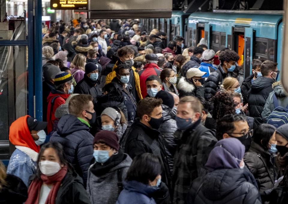 FILE - People with face masks stand close together as they wait for a subway train in Frankfurt, Germany, Wednesday, Dec. 2, 2020. Germany is set to mark 100,000 deaths from COVID-19 this week, passing a somber milestone that several of its neighbors crossed months ago but which some in Western Europe's most populous nation had hoped to avoid. (AP Photo/Michael Probst)