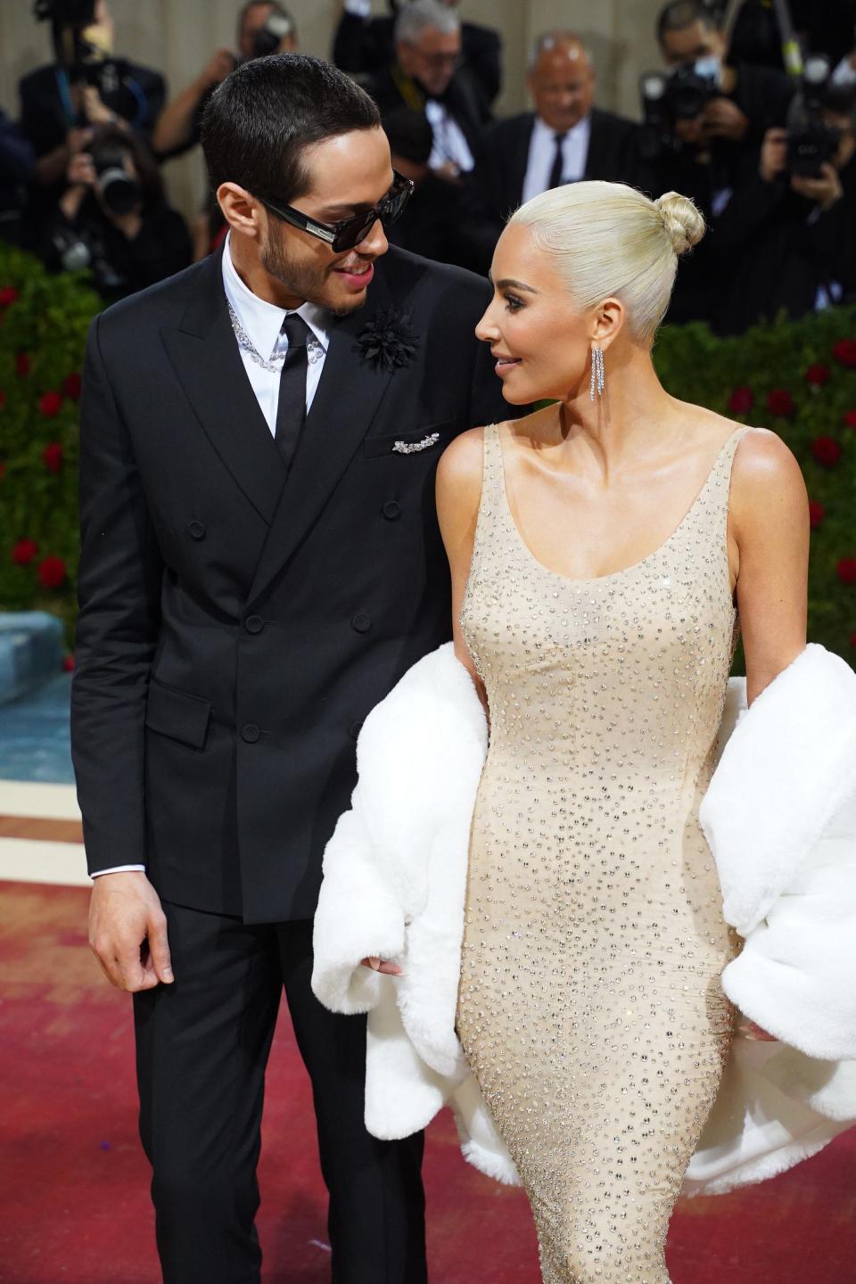 Pete Davidson and Kim Kardashian look at each other on the Met Gala steps.