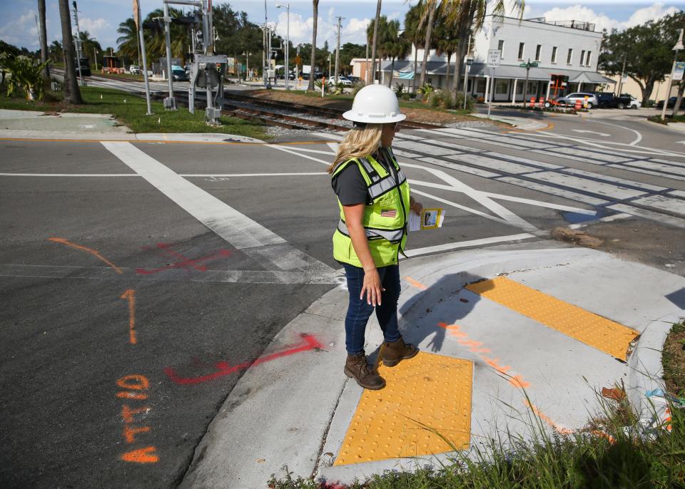 Brightline spokesperson Katie Mitzner gives a tour of the new safety improvements at the Northeast Jensen Beach Boulevard roundabout on Friday, Oct. 14, 2022. New signal systems, pedestrian gates, pavement markings and a median were some of the improvements Mitzner pointed out. Where trains operate at 110 mph, all crossings will have quad gates or medians to prevent motorists from driving around lowered crossing gates.