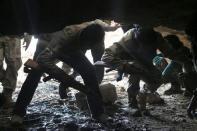 Free Syrian Army fighters enter a cave after what they said was a barrel bomb dropped by forces loyal to Syria's President Bashar al-Assad near Tal Meleh village in Hama countryside May 12, 2015. REUTERS/Mohamad Bayoush